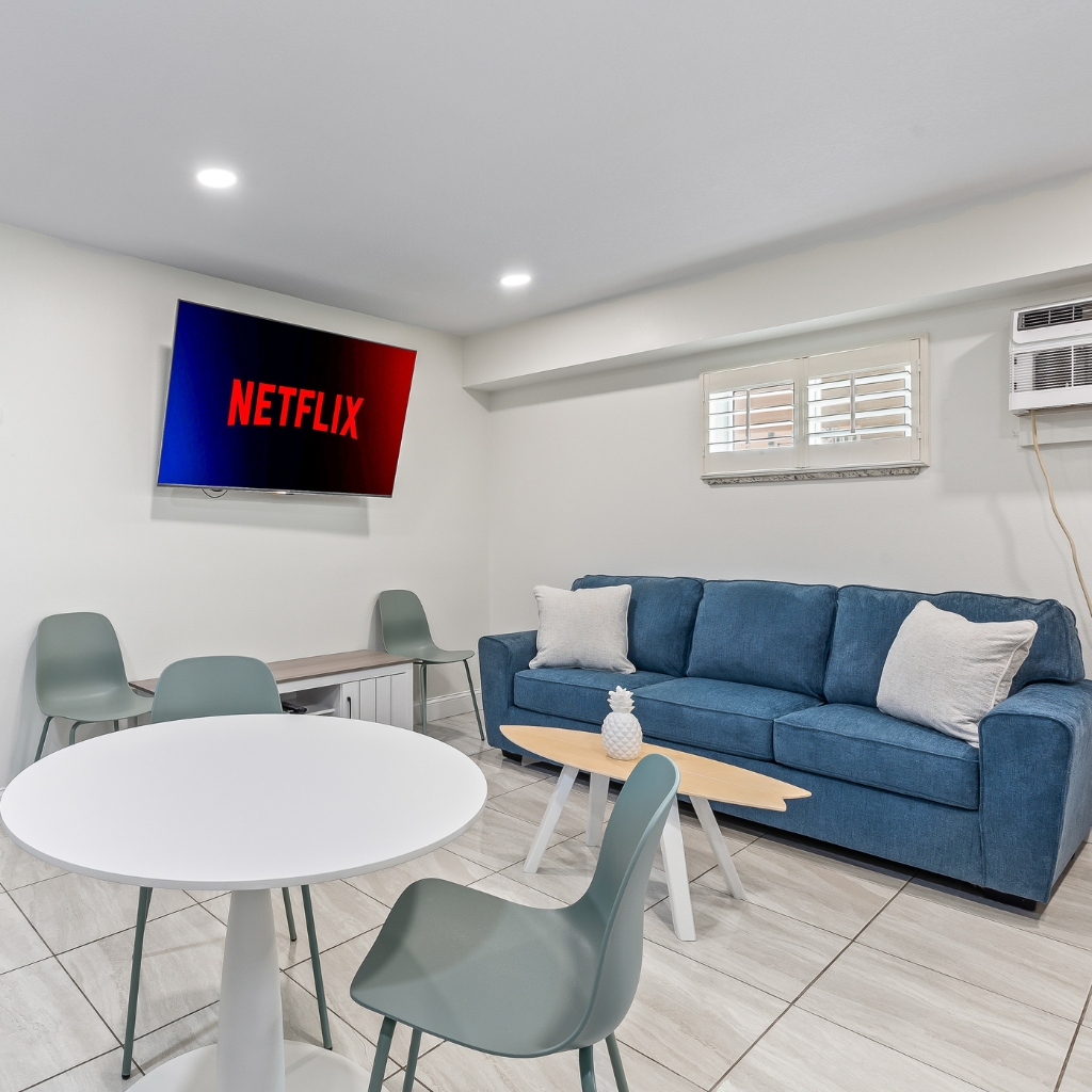Condo living room space at Atlantic Shores Motel in Daytona Beach featuring modern seating, dining area, and bright coastal design.